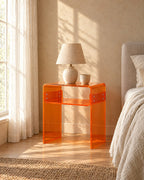 Amber acrylic bedside table in warm morning light