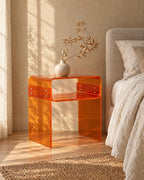 Three-quarter view of the amber acrylic bedside table