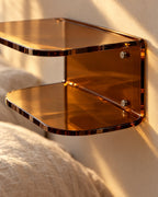 Close-up detail of the amber acrylic floating bedside shelf