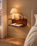 Amber acrylic floating bedside shelf with a lamp switched on and an open book in the evening
