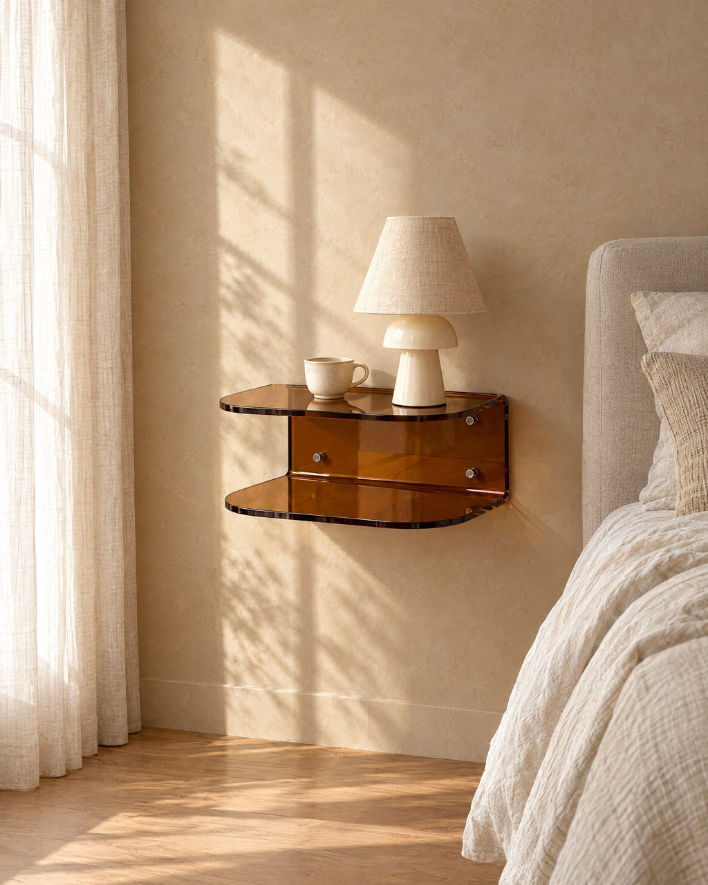Amber acrylic floating bedside shelf with a ceramic lamp in warm morning light