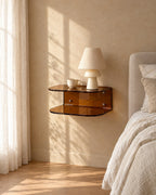 Amber acrylic floating bedside shelf with a ceramic lamp in warm morning light