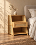 Three-quarter view of the bamboo bedside table showing its sloping rattan sides