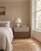 Two-tone bedside table with a built-in safe beside a bed in a British bedroom