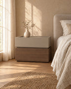 Three-quarter view of the two-tone bedside table showing the recessed plinth