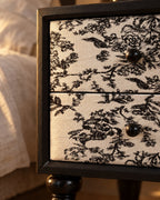 Close-up of the black and ivory floral toile drawer front with its round black knob