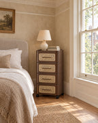 Brown four-drawer bedside chest beside a linen bed in a British bedroom with a sash window