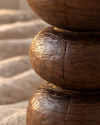 Close-up of the carved dark brown wood with tool marks and natural grain