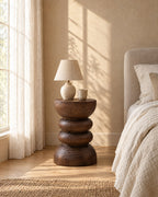 Carved wood pedestal bedside table in warm morning light
