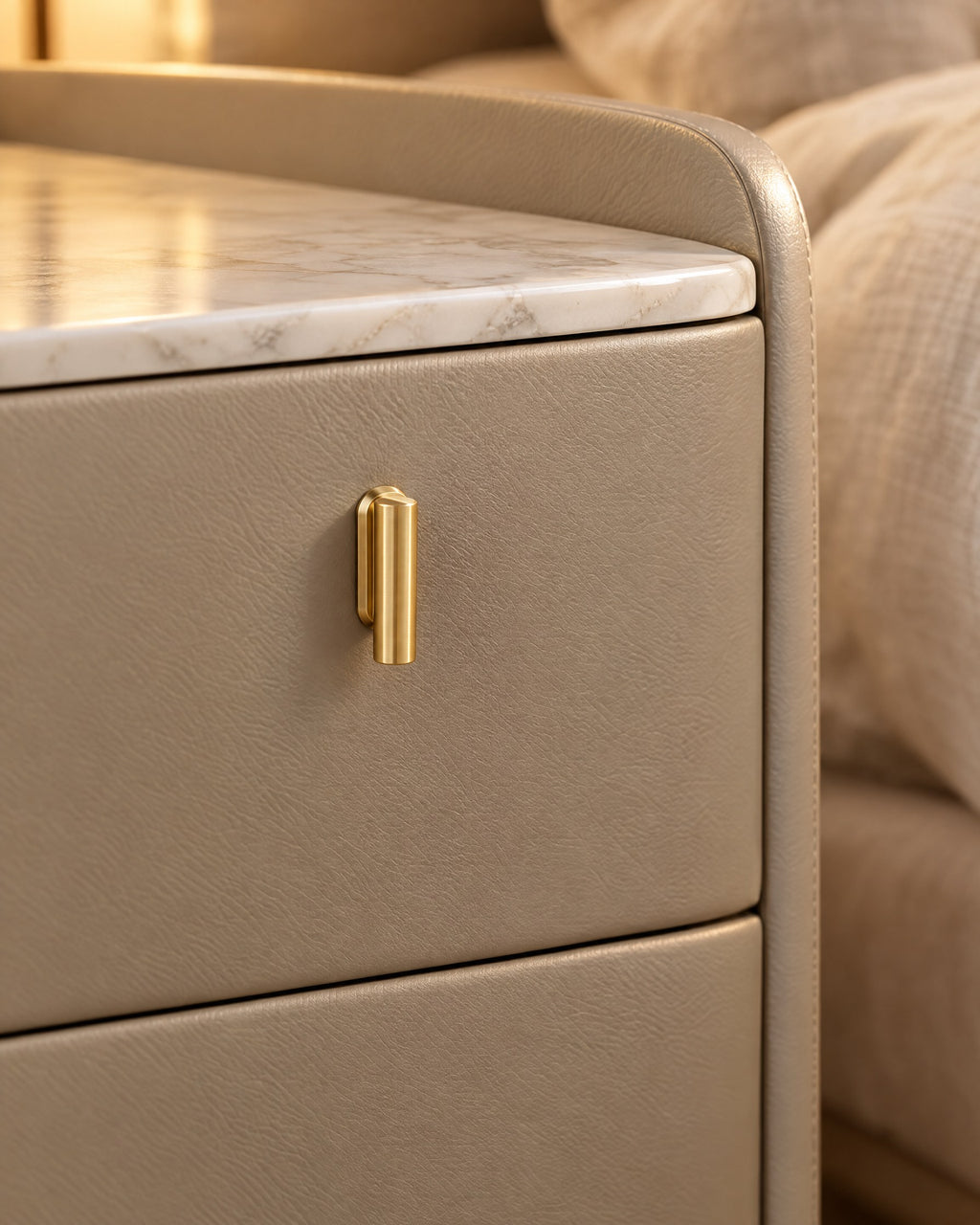 Close-up of the brushed-gold pull on the champagne grey faux leather drawer