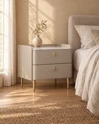 Three-quarter view of the champagne grey bedside table showing its slim gold legs