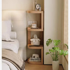 Corner shelf with four tiers tucked beside a bed