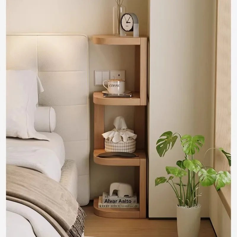 Corner shelf with four tiers tucked beside a bed