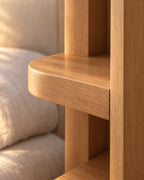 Close-up of the rounded front edge of a shelf and the light oak grain