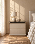 Cream faux leather bedside table with a ceramic lamp in morning light