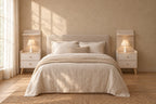 Pair of cream bedside tables with a shelf and two drawers on each side of a double bed