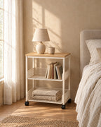 Cream bedside trolley with books in its baskets in morning light
