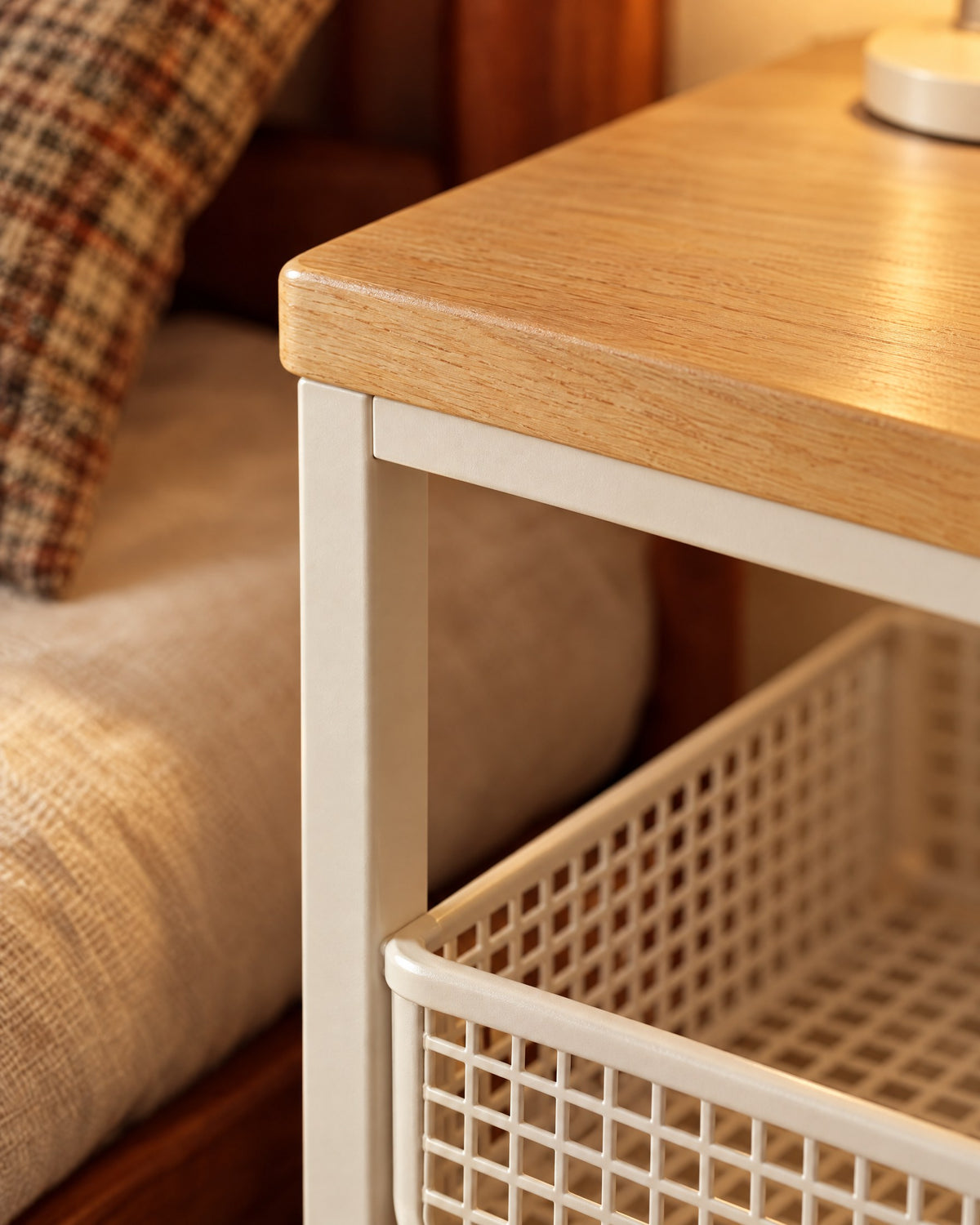 Close-up of the wood-effect top, cream metal frame and mesh basket