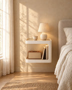 Cream floating bedside table with a ceramic lamp in warm morning light
