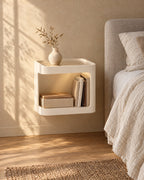 Three-quarter view of the cream floating bedside table fixed to the wall above a clear floor