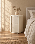 Three-quarter view of the cream bedside table with its rounded frame
