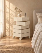Cream bedside storage unit with two trays swivelled open, on castors