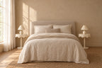 Pair of cream round pedestal bedside tables on each side of a double bed