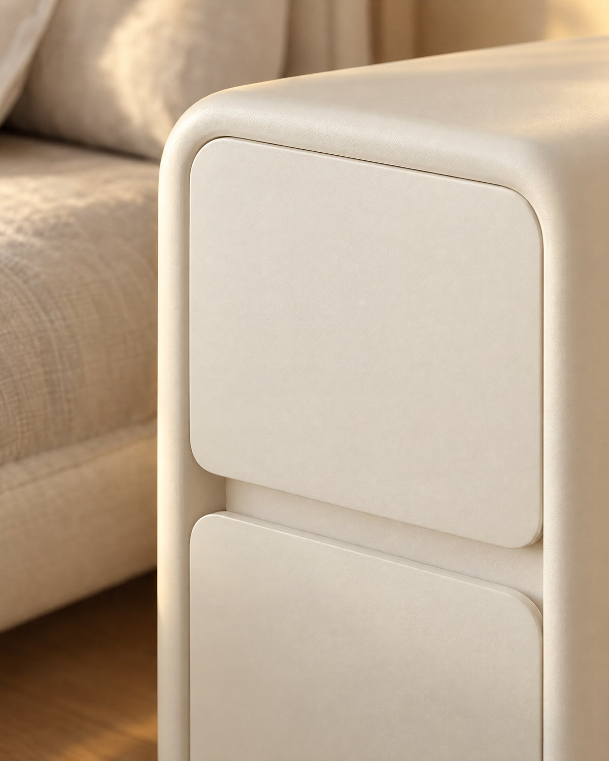 Close-up of the rounded corner and handle-free drawers of the cream bedside table