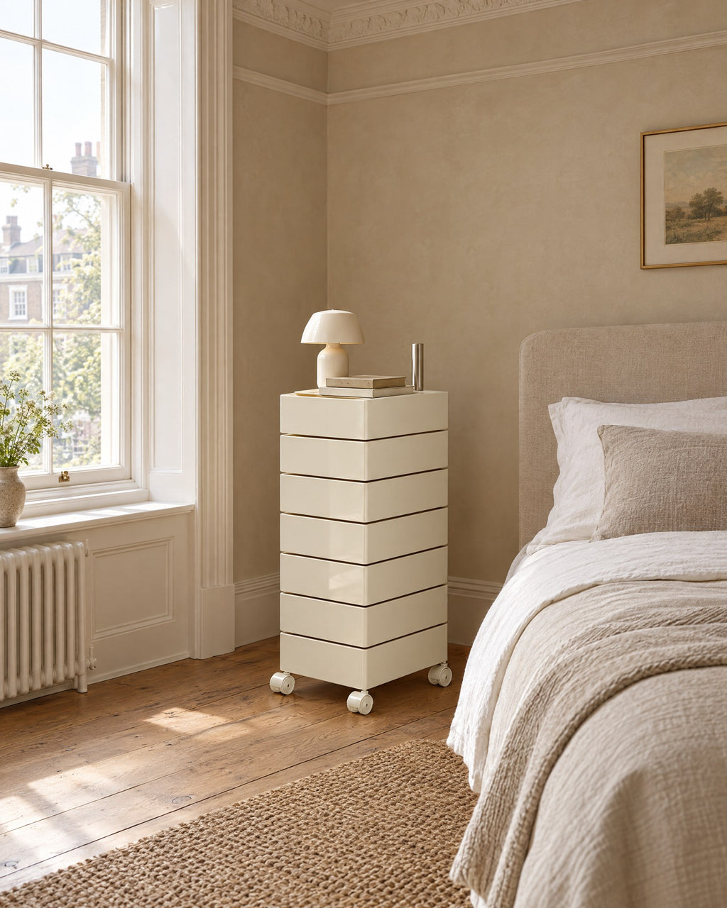 Cream swivel drawer tower beside a linen bed in a British bedroom with a sash window
