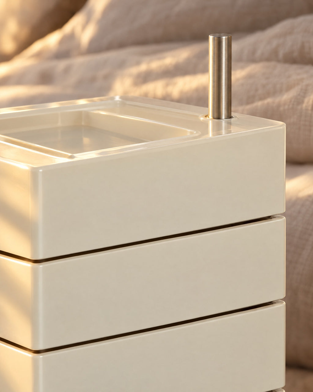 Close-up of the tray top and brushed-steel pivot of the cream drawer tower