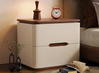Cream bedside table with a walnut top and an alarm clock beside a bed