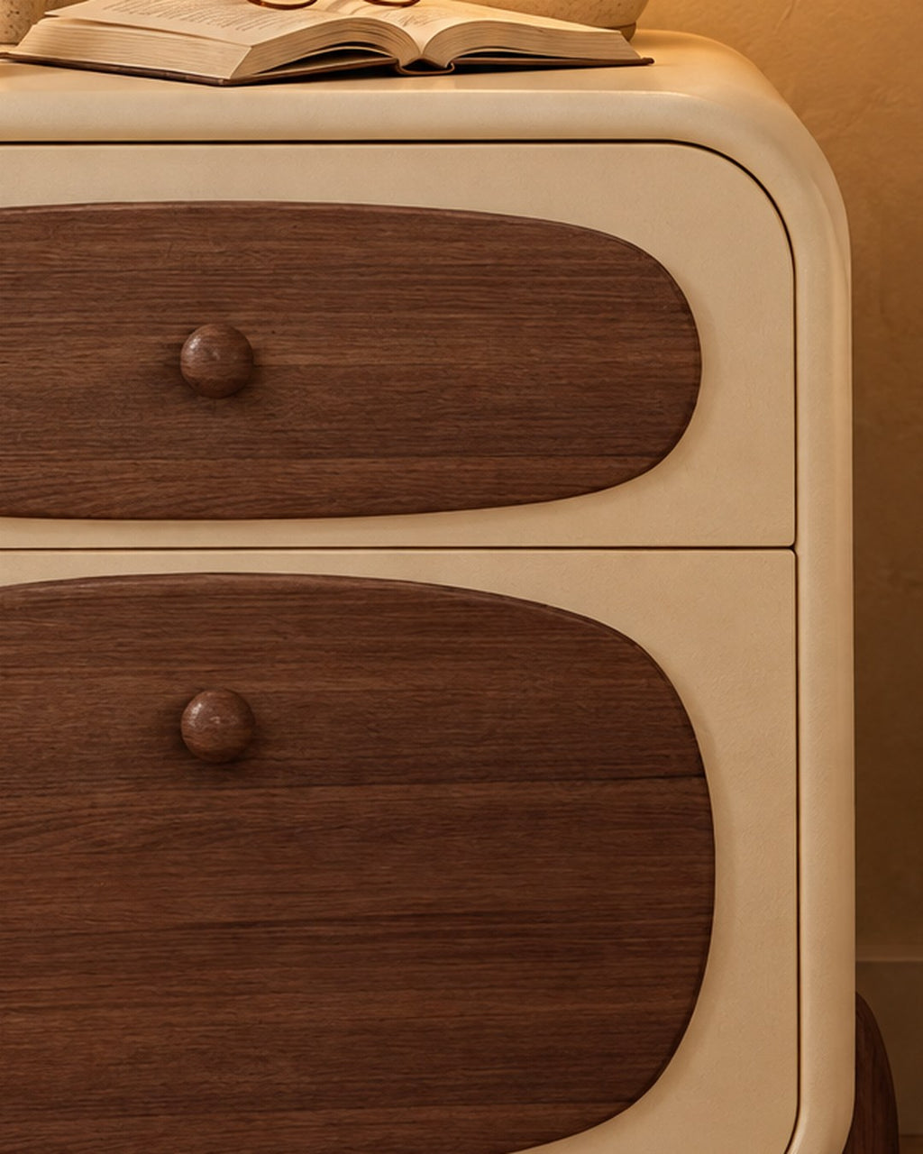Close-up of the rounded walnut drawer front and its small round knob
