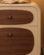 Close-up of the rounded walnut drawer front and its small round knob