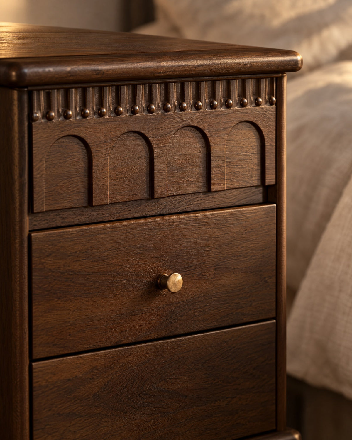 Close-up of the carved arched top drawer and the brass knob