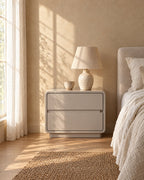 Greige lacquered bedside table with a ceramic lamp in morning light
