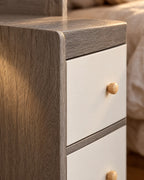 Close-up detail of the grey bedside table with two white drawers and a raised shelf