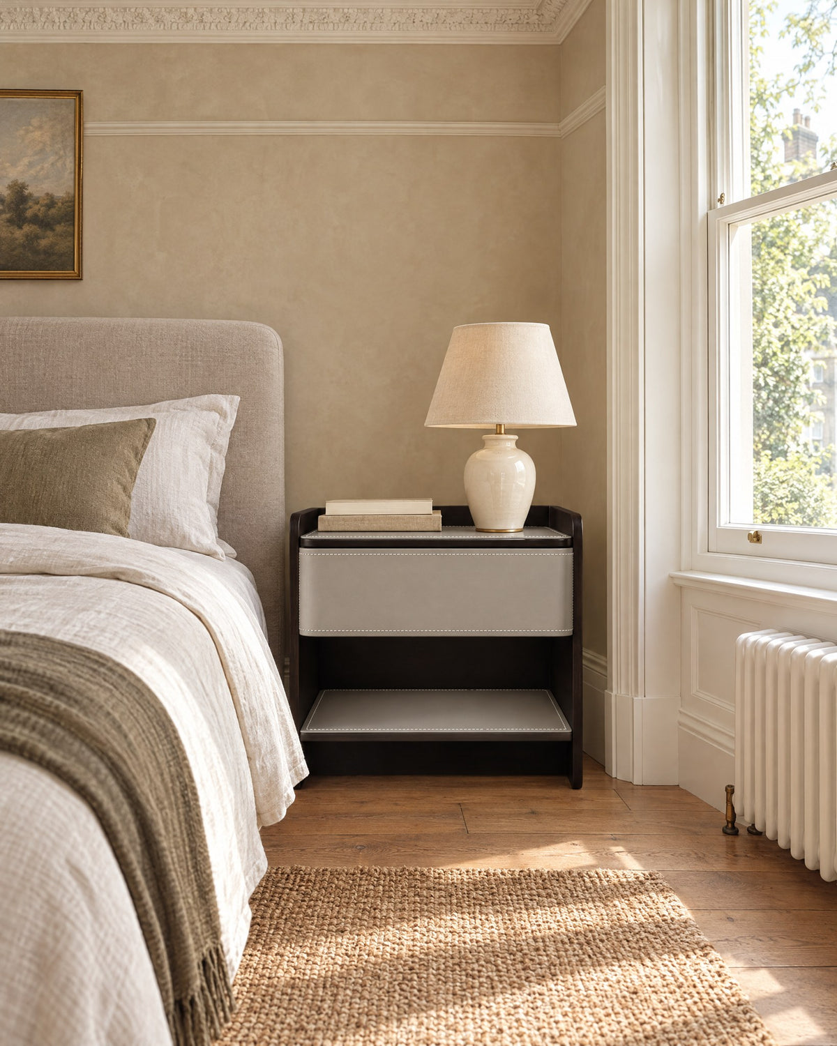 Grey and espresso bedside table with a drawer and open shelf beside a linen bed in a British bedroom