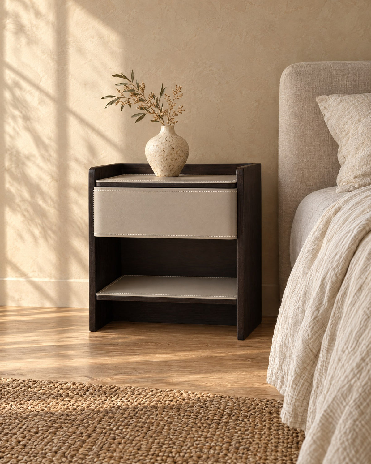 Three-quarter view of the grey and espresso bedside table showing its open shelf