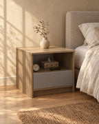 Three-quarter view of the grey oak bedside table showing the open niche and floor-standing sides