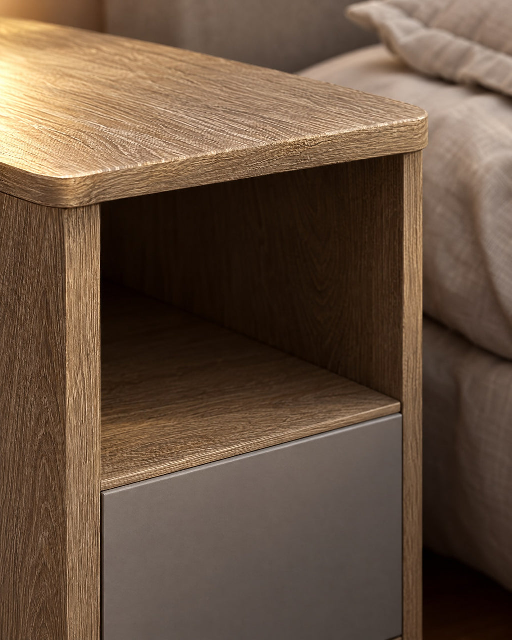 Close-up of the rounded oak-effect top edge and the matt grey drawer front
