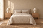 Two honey wood bedside tables with two drawers and square legs on each side of a double bed