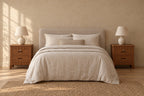 Pair of lockable brown wooden bedside tables with two drawers and scalloped rails either side of a double bed