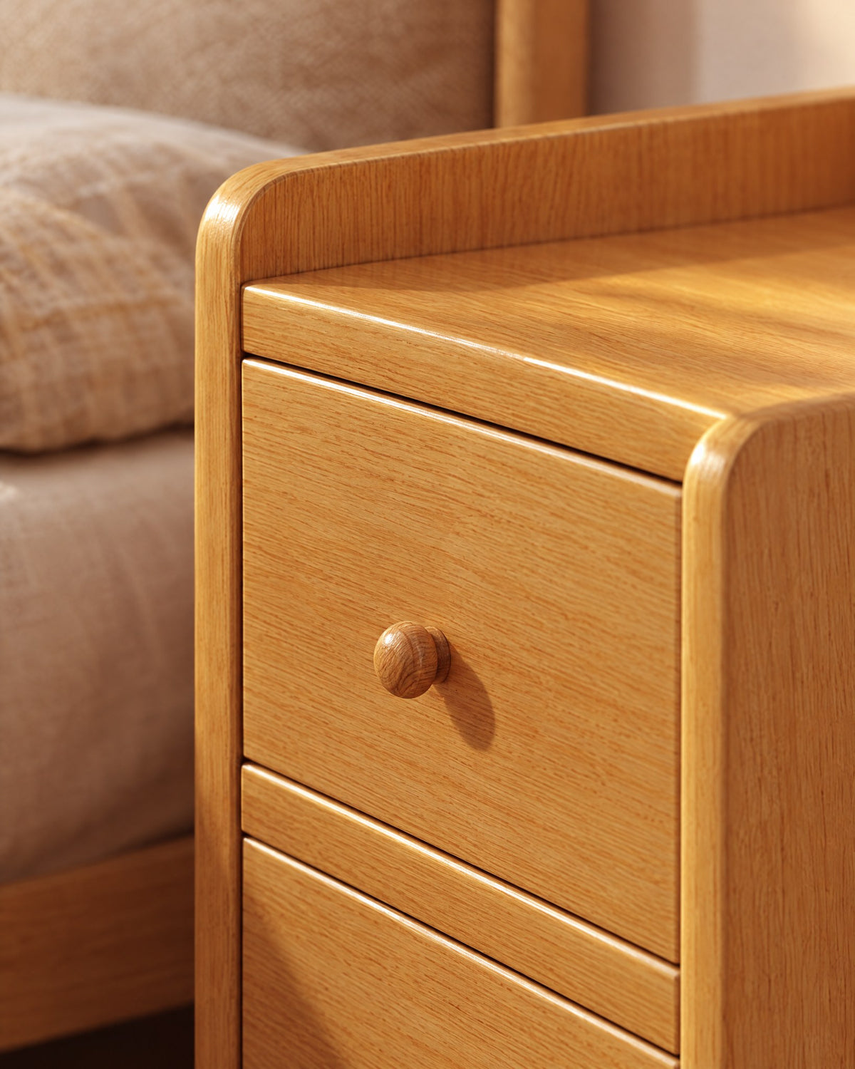 Close-up of the raised rim and a round wooden knob on the cherry bedside table