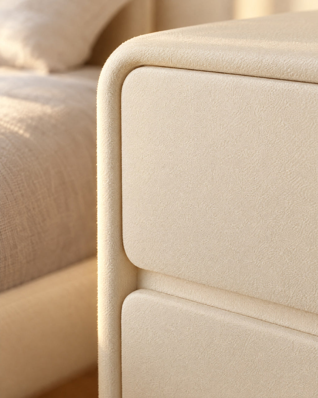 Close-up of the rounded corner and handle-free drawer fronts in matte cream