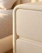 Close-up of the rounded corner and handle-free drawer fronts in matte cream