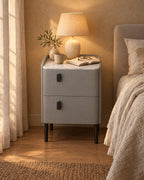 Narrow Grey Bedside Table with a lamp switched on and an open book in the evening