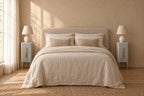 Pair of narrow grey bedside tables with gold legs on each side of a double bed