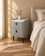 Three-quarter view of the narrow grey bedside table on slim black legs