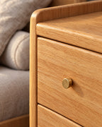 Close-up of the brass knob and the oak grain of the drawer