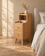 Three-quarter view of the narrow oak bedside table showing its tapered legs